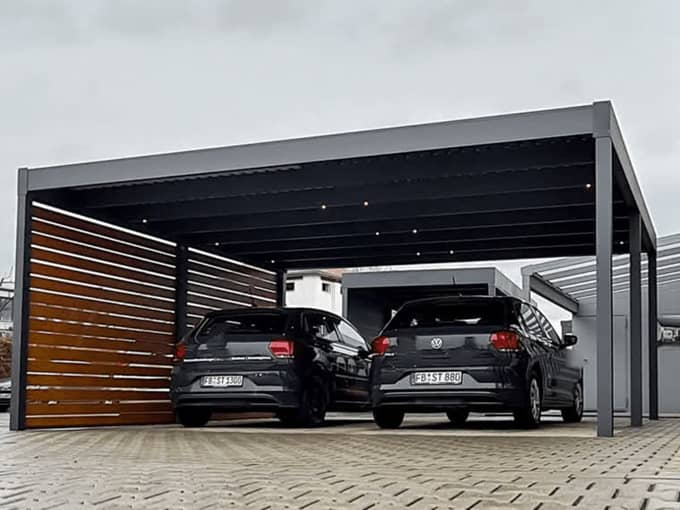 Aluminium-Doppelcarport in Anthrazit mit Holz-Sichtschutzwand und zwei geparkten Fahrzeugen – Terravista Meppen