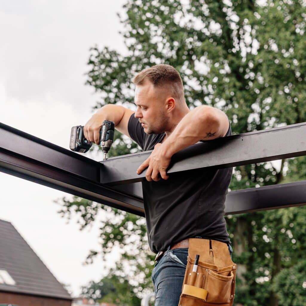 Daniel Appelhans von Terravista Meppen montiert ein maßgefertigtes Aluminium-Carport als langlebigen Wetterschutz im Emsland.